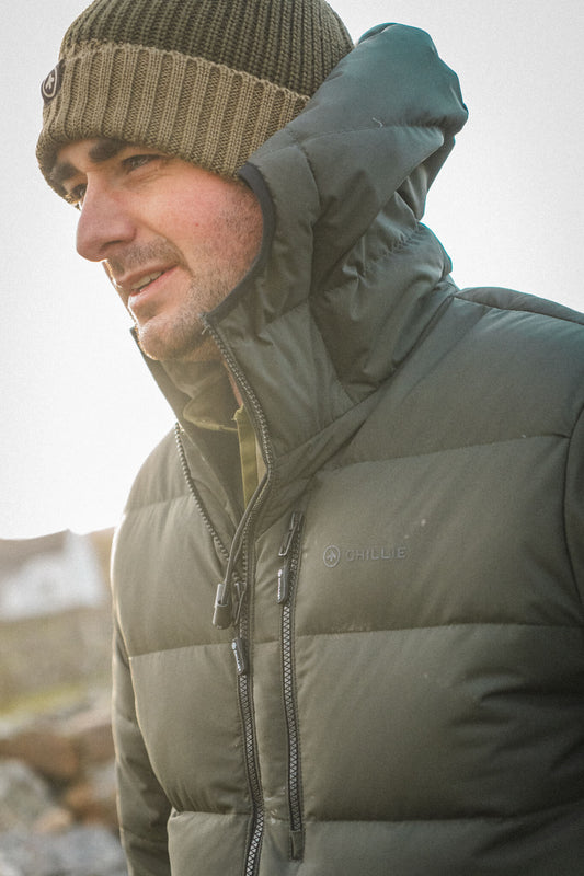 Corrie Down Jacket in Dark Forest Green with a Highlander Beanie in Heather Green, close view of the baffles and chest zip.