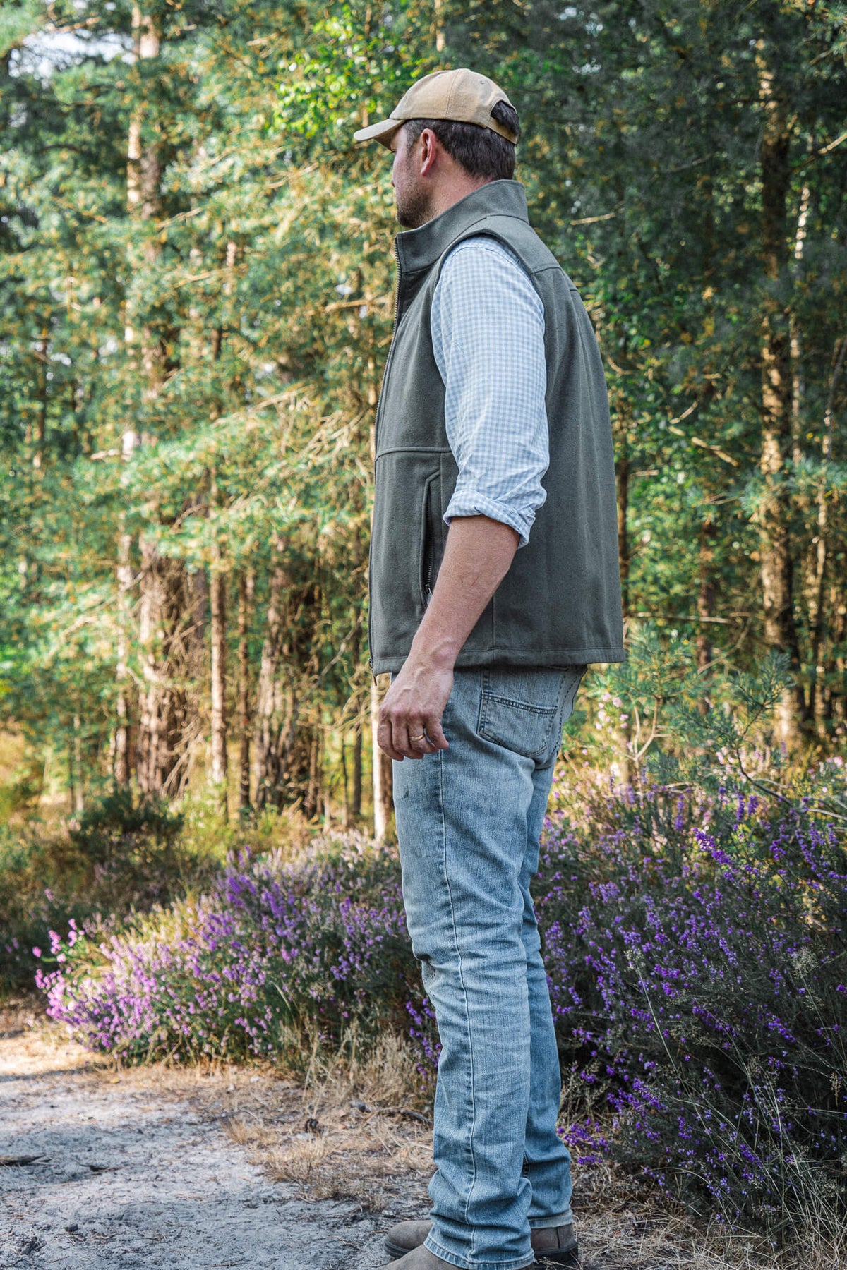 Torr Wool Gilet in Heather Green, worn facing away on a forest track.