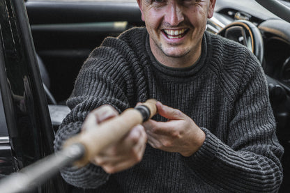 Tarbert Fisherman's Jumper in Slate, worn setting up a rod at the tailgate.