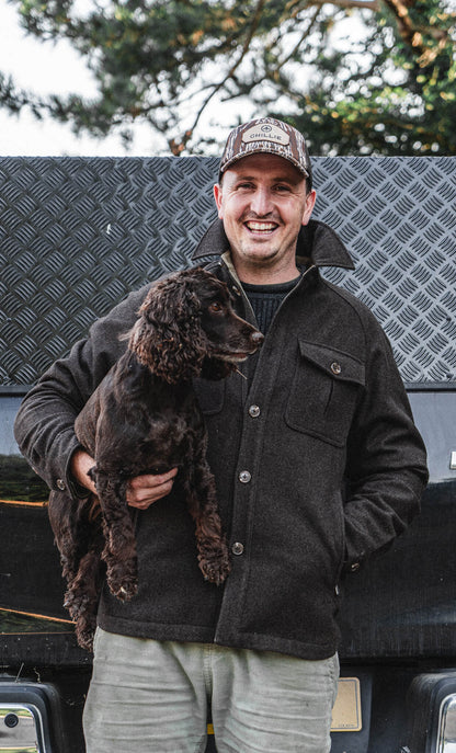 Arkle Wool Jacket, worn holding a spaniel at the back of a truck.