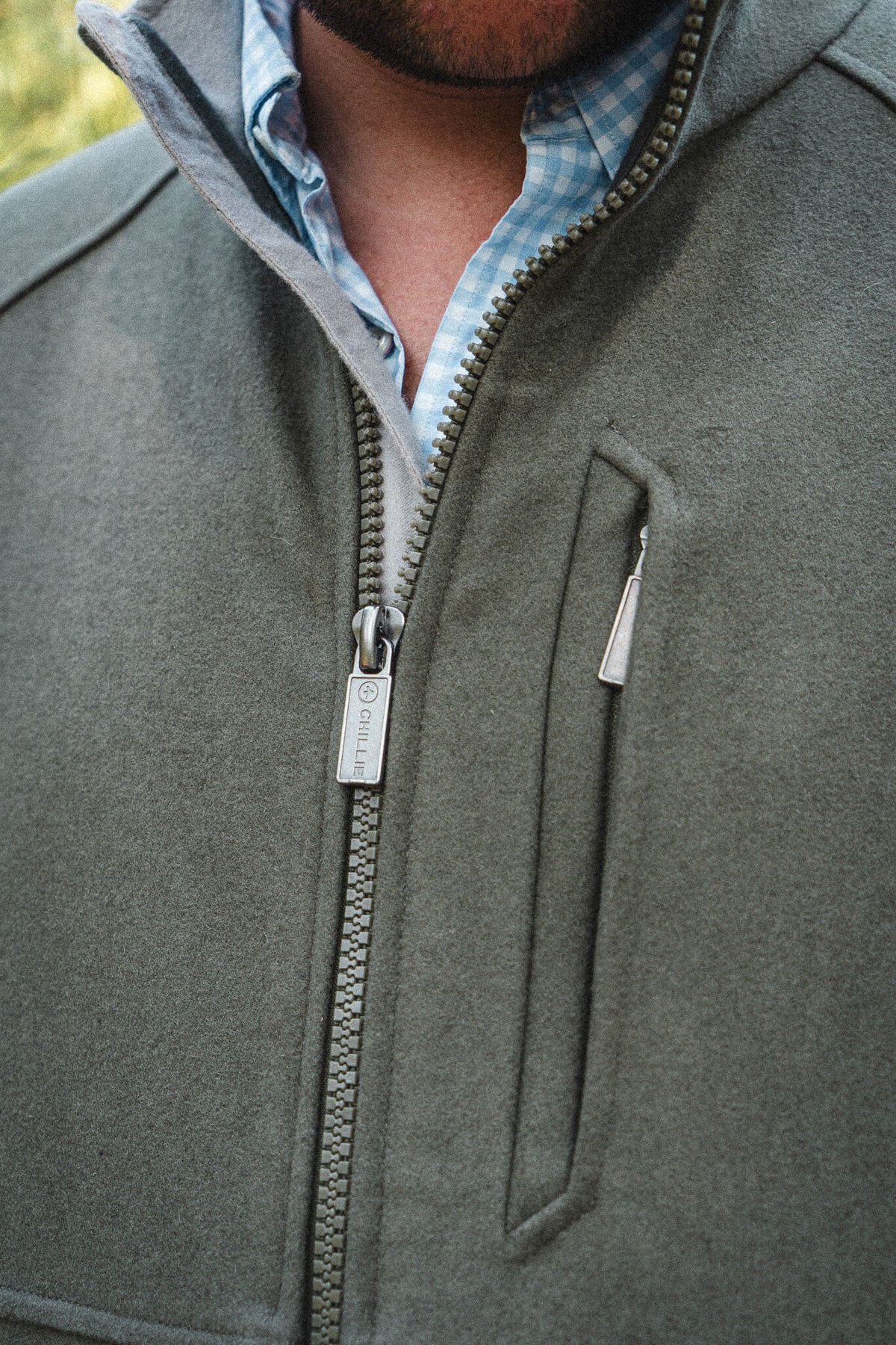 Torr Wool Gilet in Heather Green, close view of the zip and welted hand pocket.