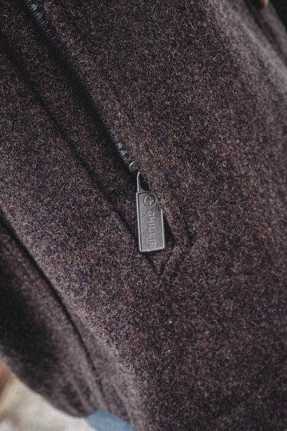 Arkle Wool Jacket, close view of the dark brown wool and the metal pocket zip pull stamped with the Ghillie name.